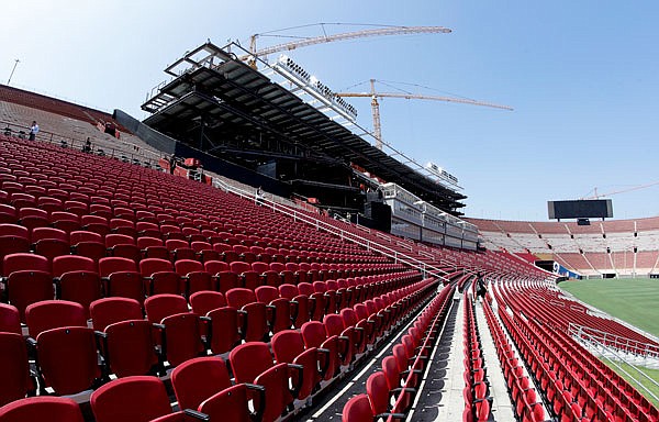 Stadium personnel walk near a new section of seats Wednesday at the Los Angeles Memorial Coliseum in Los Angeles.