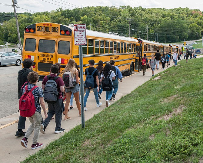 Jefferson City High School students head to the line of buses waiting in the loading zone Thursday, Aug. 16, 2018, on Lafayette Street at the conclusion of the first day of school.