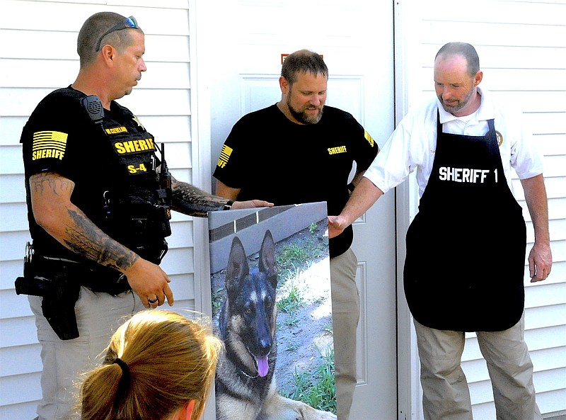 Moniteau County Sheriff Tony Wheatley received a painting of K-9 Mizzou at the open house for the department's new offices Aug. 17, 2018. Lt. Wayne Cleveland and Lt. Skyler Viebrock, representing the staff of the Sheriff's Office and jail, made the presentation, which also included a gift certificate for Wheatley's wife, Dana.