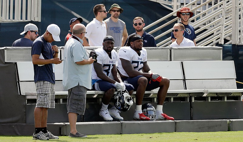 Tennessee Titans running backs Dion Lewis (33) and Derrick Henry (22) rest on a cooling bench during NFL football training camp Wednesday, Aug. 15, 2018, in Nashville, Tenn. The Titans put a bench on each side of their three practice fields, giving players a chance to recover when the temperature during morning practices can feel like 90 degrees. (AP Photo/Mark Humphrey)