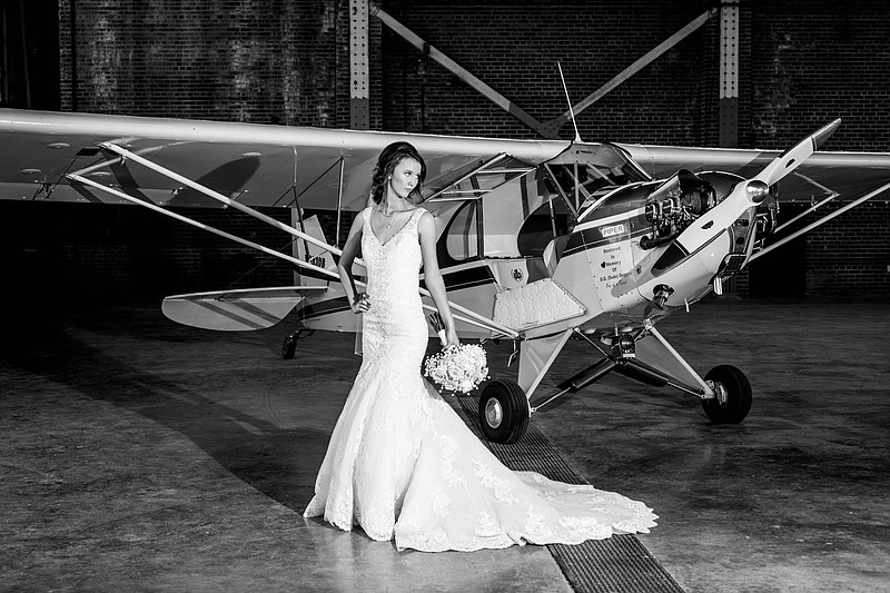 Natalie Hood poses in front of a single-engine 1940 Piper at Hope Municipal Airport in Hope, Ark. Hood and Hayden Halbert were married June 2 in the city-owned historic airport. (Photo courtesy of Heather Clements Photography)