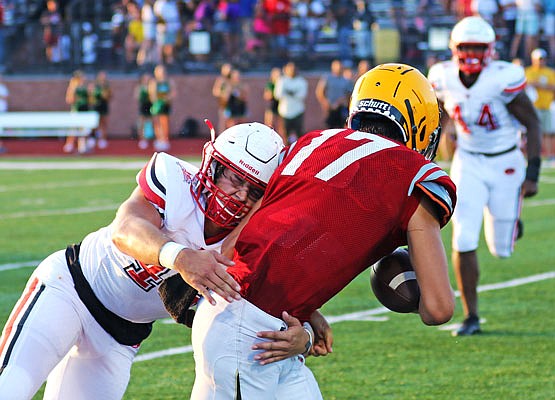 Ian Cote of the Jefferson City Jays tackles the Rock Bridge quarterback during Friday night's Jamboree in Columbia.