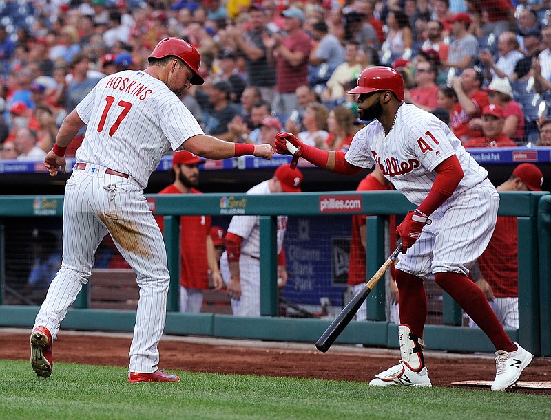 Philadelphia Phillies' Rhys Hoskins (17) celebrates with Carlos Santana (41) after scoring a run on a Nick Williams single during the first inning of a baseball game against the New York Mets, Friday, Aug. 17, 2018, in Philadelphia. (AP Photo/Michael Perez)