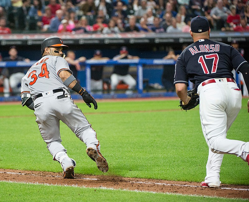 Baltimore Orioles' Jonathan Villar runs back towards home plate as Cleveland Indians' Yonder Alonso chases him during the eighth inning a baseball game in Cleveland, Friday, Aug. 17, 2018. (AP Photo/Phil Long)