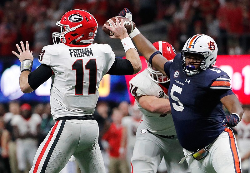 In this Dec. 2, 2017, file photo, Georgia quarterback Jake Fromm (11) looks to throw a pass as Auburn defensive lineman Derrick Brown (5) pressures during the second half of the Southeastern Conference championship NCAA college football game in Atlanta. Auburn and Georgia meet Nov. 10 in a rematch from last year's SEC title game. (AP Photo/David Goldman, File)