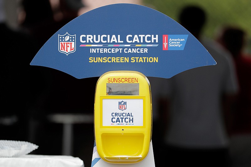 A sunscreen dispenser is seen in the fan section at the New York Giants NFL football training camp, Thursday, Aug. 2, 2018, in East Rutherford, N.J. The NFL and American Cancer Society teamed up this summer to launch an initiative as part of its "Crucial Catch" campaign in which free sunscreen is being provided to players, coaches, fans, team employees and media at camps across the country. (AP Photo/Julio Cortez)