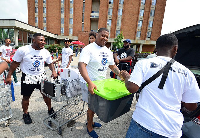 D'Angelo Bratton-Bland, center, Student Government Association president, helps Nadaniel Johnson move into Dawson Hall on Saturday, Aug. 18, 2018, at Lincoln University for the start of the new school year. 