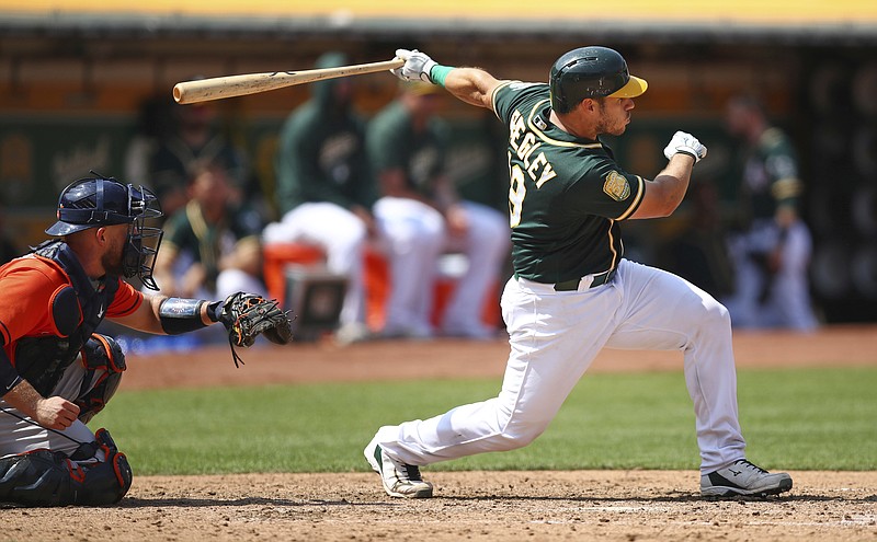 Oakland Athletics' Josh Phegley, right, swings for an RBI-double off Houston Astros' Dallas Keuchel in the sixth inning of a baseball game Saturday, Aug. 18, 2018, in Oakland, Calif. (AP Photo/Ben Margot)