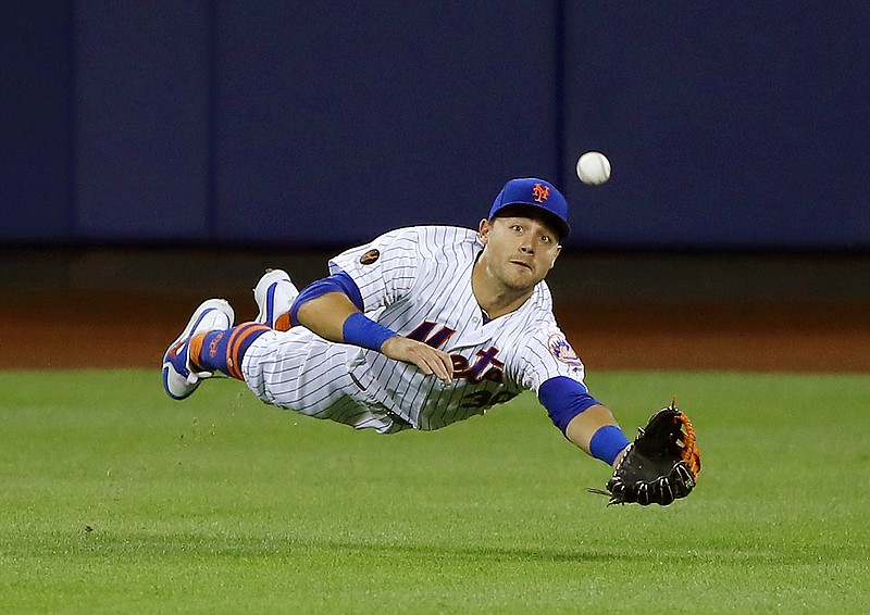 In this  June 23, 2018 file photo New York Mets center fielder Michael Conforto dives for but can't make the play on a ball hit by Los Angeles Dodgers' Yasiel Puig during the eighth inning of a baseball game in New York. Some talented, young baseball players have competed at the Little League World Series over the last 71 years. Fifty-four have gone on to realize another dream—making the majors. Conforto will be one of the three Little League veterans on hand when the Mets play the Phillies in central Pennsylvania on Sunday, Aug. 19, 2018. (AP Photo/Julie Jacobson, file)