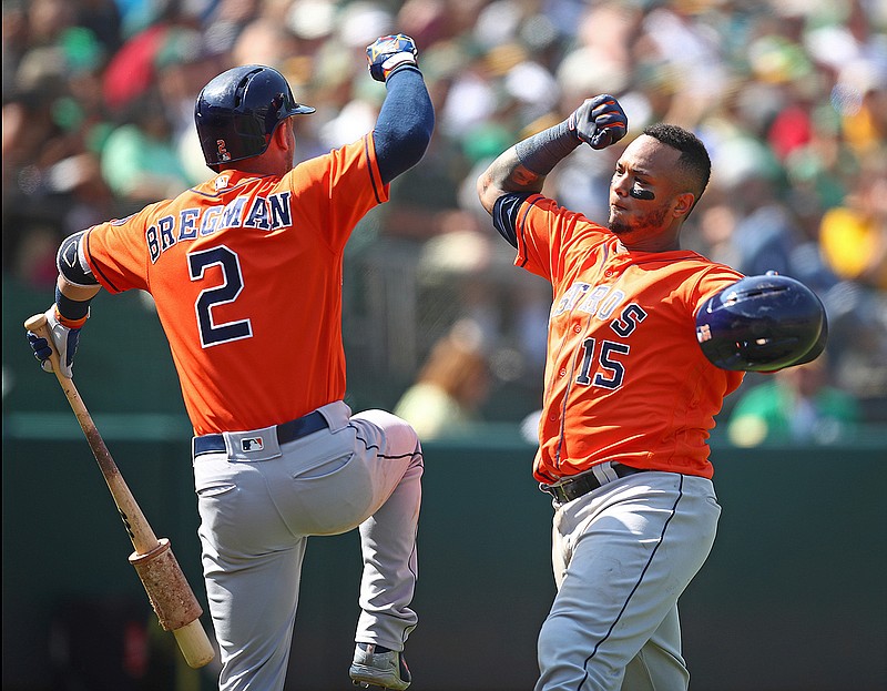 Houston Astros' Martin Maldonado, right, celebrates with Alex Bregman (2) after hitting a home run off Oakland Athletics' Emilio Pagan in the seventh inning of a baseball game Sunday in Oakland, Calif.