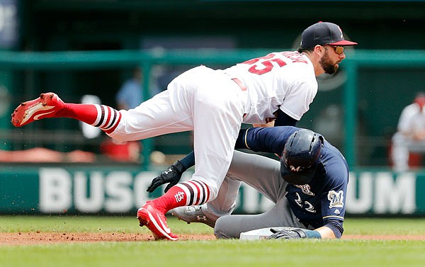 Cardinals second baseman Greg Garcia falls over Christian Yelich of the Brewers while turning a double play during the first inning of Sunday afternoon's game at Busch Stadium.