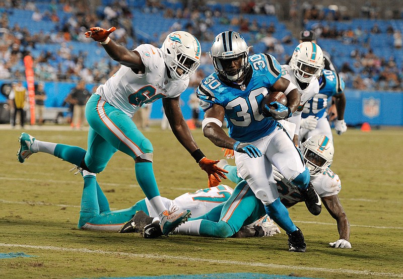 Carolina Panthers' Elijah Hood (30) runs past Miami Dolphins' Claudy Mathieu (60) for a touchdown in the second half of a preseason NFL football game Friday in Charlotte, N.C.