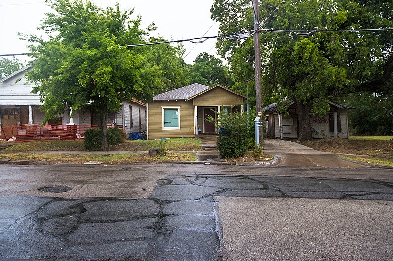 An Aug. 10, 2018 photo shows from left, a vacant house that had a fire, a remodeled house and a vacant house in the neighborhood where architect Jay Taylor is building homes in Dallas. Taylor said the three homes were a good representation of the neighborhoods current state. The properties are in the 10th Street neighborhood, a historic district and former "freedmen's town" founded by freed slaves after the Civil War. (Carly Geraci/The Dallas Morning News via AP)