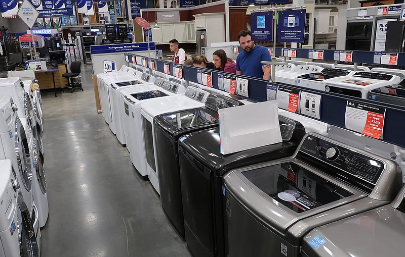 FILE- In this May 21, 2018, file photo, a family shops for washing and drying machines at Lowe's Home Improvement store in East Rutherford, N.J. On Friday, Aug. 24, the Commerce Department releases its July report on durable goods. (AP Photo/Ted Shaffrey, File)