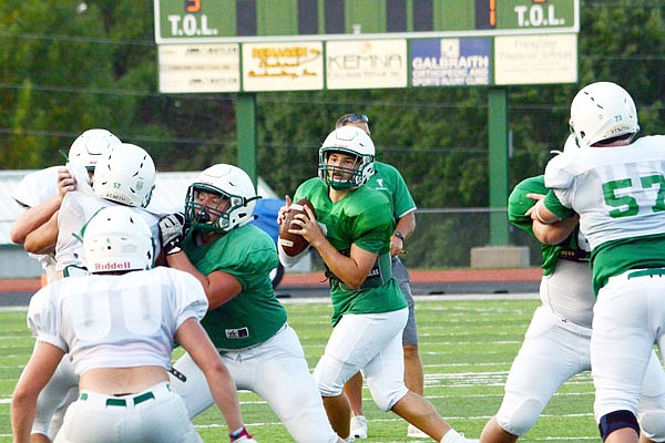 Blair Oaks senior quarterback Nolan Hair (center) gets ready to pass during the Green and White Scrimmage earlier this month at the Falcon Athletic Complex in Wardsville.