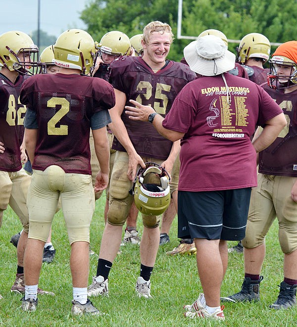 Eldon quarterback Dawson Brant smiles while talking to a coach during a recent practice at the school.