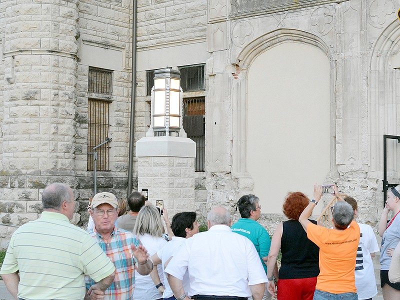Guests take photos of one of the restored lights Monday during a lighting ceremony at the historic Missouri State Penitentiary. The lights were originally installed at the prison in 1938 and then taken down to be used at the new Missouri Department of Corrections. When the new prison didn't need the lighting they were put in storage until they could be restored. 