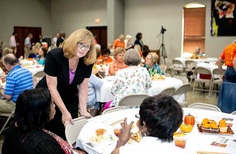 Adra Hallford, board president of the Harvest Regional Food Bank, talks to a group of volunteers at a lunch table on Tuesday in Texarkana, Texas. The luncheon was held at Williams Memorial Methodist Church to thank the organizations and agencies of volunteers for helping distribute food.