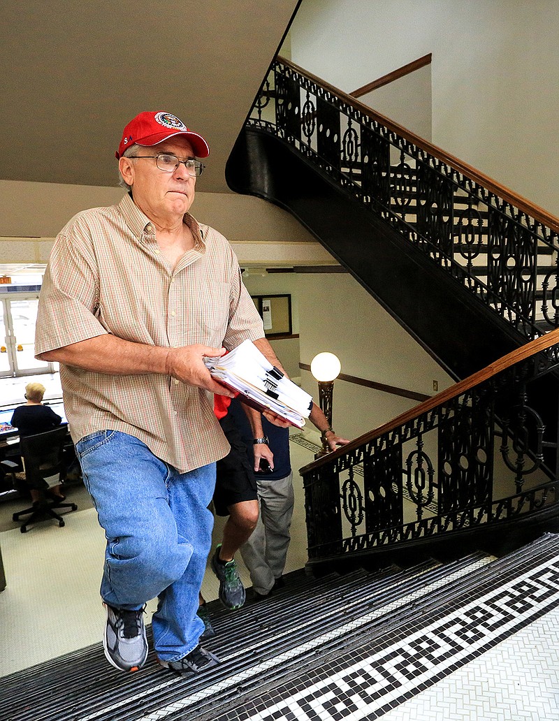 File Photo (8/30/2018) Lynn Kuznoff carries a packet of anti-annexation petitions up the stairs to the city secretary's office on Thursday in Texarkana, Texas. Kuznoff, along with half a dozen other residents, went to the office to turn in the petitions with an average of 450 signatures each to repeal the recent annexation of land by the city.