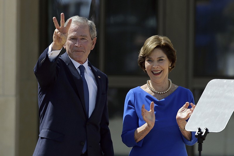 In this April 25, 2013, file photo, former President George W. Bush, accompanied by his wife, former first lady Laura Bush, flashes the "W" sign after his speech during the dedication of the George W. Bush Presidential Center in Dallas. Bush and former first lady Laura Bush have decided they'll be buried at his presidential library in Dallas instead of the Texas State Cemetery in Austin. (AP Photo/David J. Phillip, File)