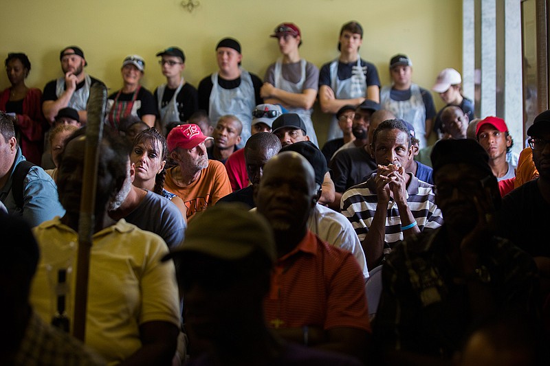 A group of people listens to the testimony of former Astros pitcher J.R. Richard about his history with homelessness at Lord of the Streets ministry, Tuesday, July 17, 2018, in Houston. ( Marie D. De Jesus/Houston Chronicle via AP)