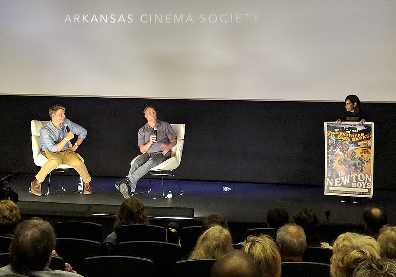 In this Aug. 23, 2018, photo director Richard Linklater tells filmmaker Jeff Nichols about a poster he had made for one of his earlier films, "The Newton Boys" at a film festival in downtown Little Rock, Ark. The festival, Filmland, was hosted by the Arkansas Cinema Society which was founded by Arkansas natives Jeff Nichols and filmmaker Kathryn Tucker. (AP Photo/Hannah Grabenstein)