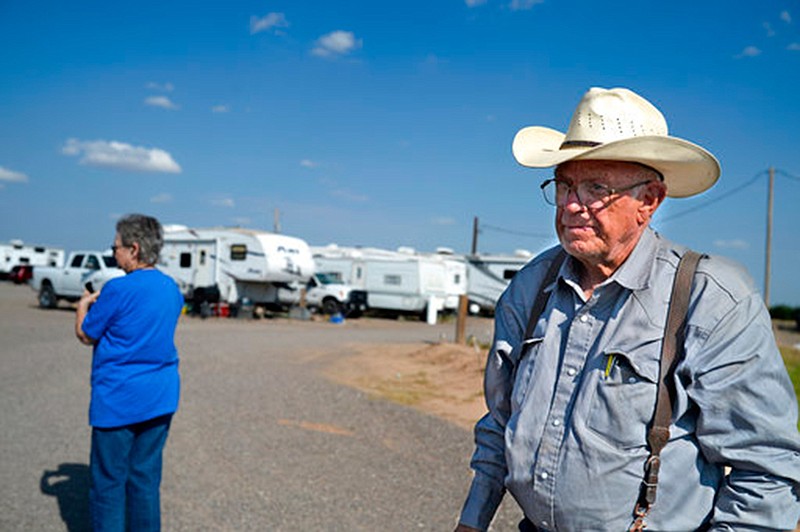 Ted and Murlene Godfrey walk through the RV park they own on July 31 near Pecos. Texas. The Godfreys have nearly tripled the size of their RV park, and people are still clamoring to live there.