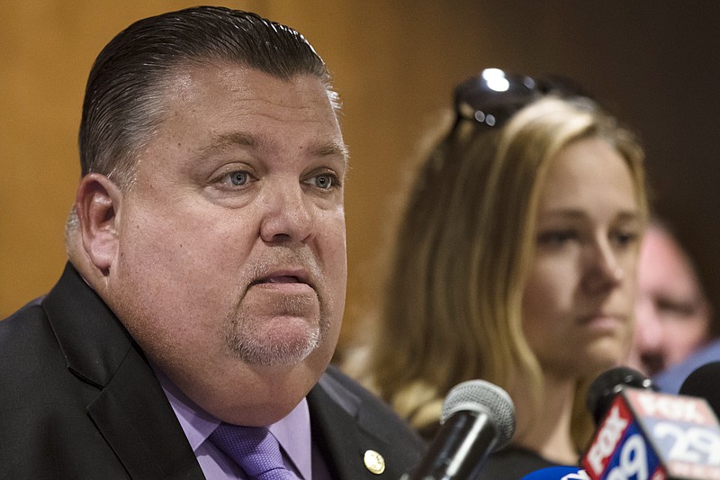 Police union President John McNesby accompanied by former Officer Ryan Pownall's wife Tina, right, speaks during a news conference in Philadelphia, Tuesday, Sept. 4, 2018. Ryan Pownall, a fired white Philadelphia police officer, has been charged with criminal homicide for fatally shooting a black man in the back after a confrontation over a dirt bike. (AP Photo/Matt Rourke)