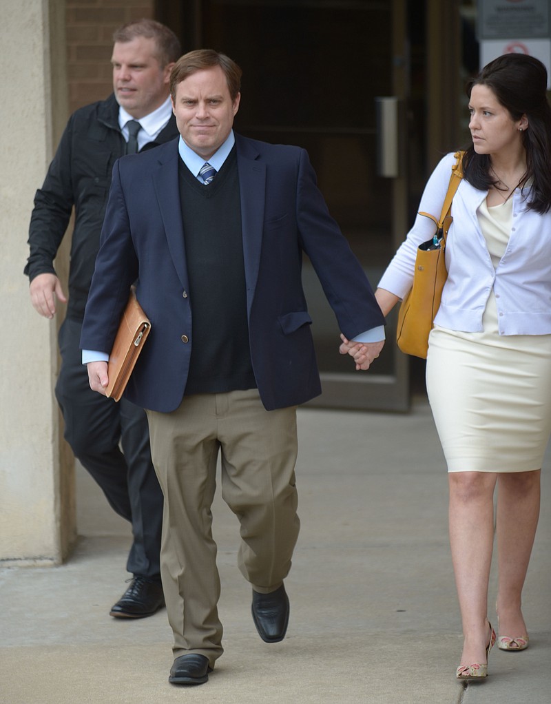 Former state Sen. Jon Woods walks Tuesday, May 1, 2018, out of the John Paul Hammerschmidt Federal Building in Fayetteville alongside his wife, Christina, and brother, Dustin Woods.