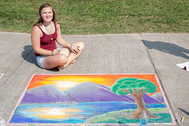 Emma Haenchen shows off her sidewalk art Sept. 9, 2017, at the Capital Chalk Art Fair at Ellis-Porter Riverside Park In Jefferson City. 