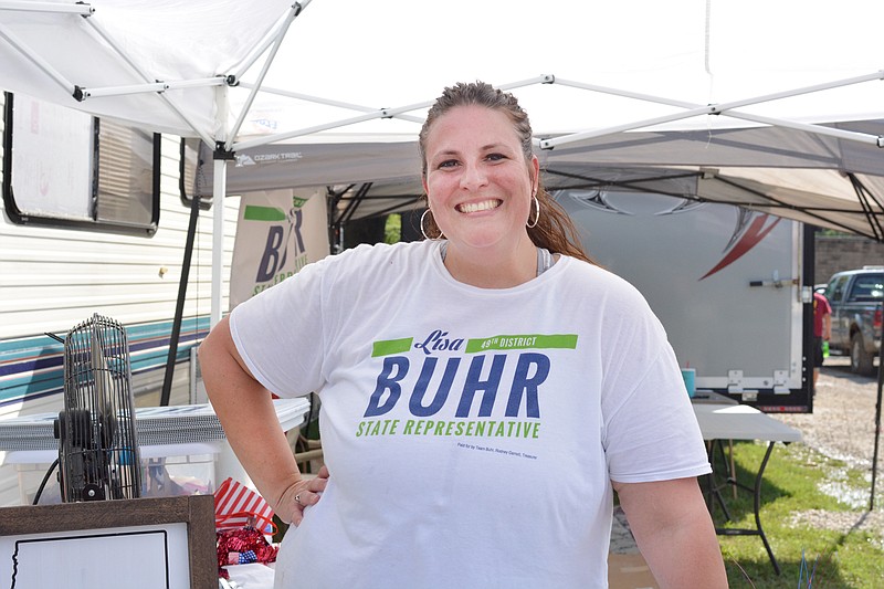 
Lisa Buhr smiles Saturday Septmber 1, 2018 as she wears a t-shirt that promotes her running for state representative during the Mokane Lions Club Fall Festival on W River Road. 