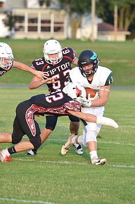 North Callaway running back Jordan Delashmutt tries to escape a tackle from Tipton's Dalton Weaver (22) as Derrick Hays (63) pursues in the background during last Friday night's game in Tipton.