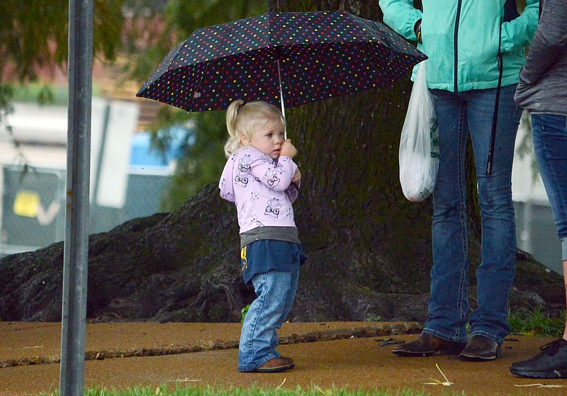 Sally Ince/ News Tribune
Bryleigh Wulff, 2, stands under her umbrella to keep out of the rain Saturday as she waits for the Labor Day Parade to begin. Wulff attended to see her father, who works for Butzer, march in the parade. 