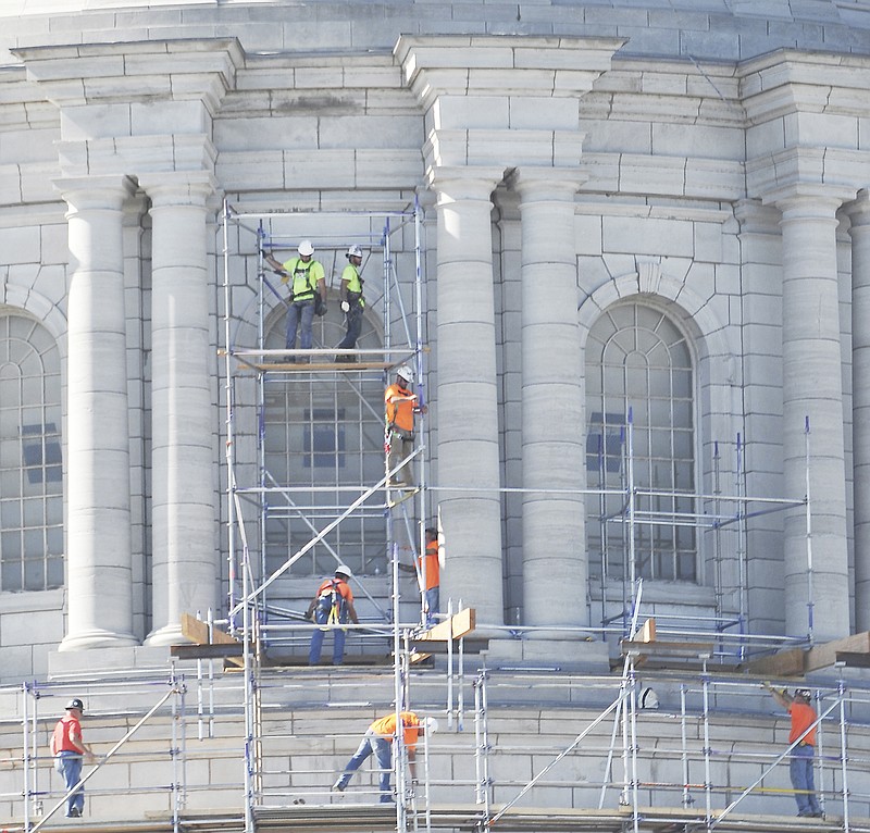A crew works Monday to set up scaffolding around the Capitol dome. They can be seen working on the building's east side as they construct the scaffolding. Before they are done, the entire dome will be surrounded in scaffolding so the necessary work can be done to repair and seal the stonework. While the crew worked outside, lawmakers work inside as a special session begins.