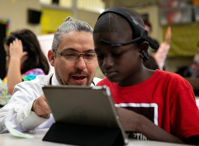 John Wick from Q-Nureo shows a student at Mineral Springs elementary how to play the game on the iPad with paired headsets that monitors and measures cognitive brainwaves on Monday, September 10, 2018 in Mineral Springs, Arkansas.