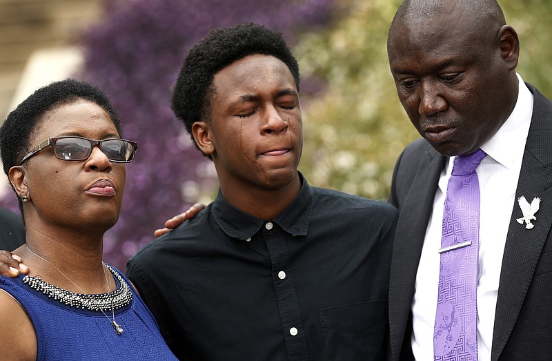 Brandt Jean, center, brother of Botham Jean, cries as he attends a news conference outside the Frank Crowley Courts Building on Monday, Sept. 10, 2018, in Dallas, about the shooting of Botham Jean by Dallas police officer Amber Guyger on Thursday. He was joined by his mother, Allison Jean and attorney Benjamin Crump. (Tom Fox/The Dallas Morning News via AP)