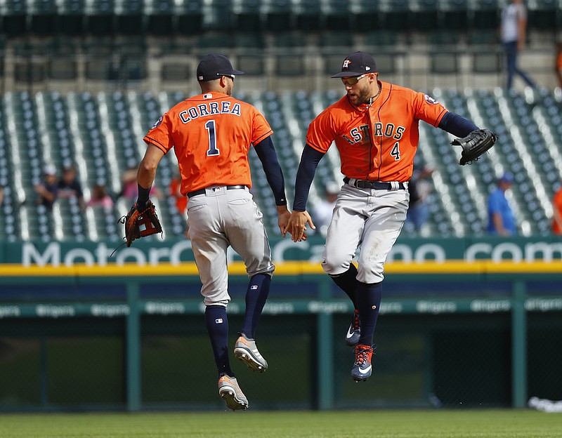 Houston Astros' Carlos Correa (1) and George Springer (4) celebrate their 5-4 win after a baseball game against the Detroit Tigers in Detroit, Wednesday, Sept. 12, 2018. (AP Photo/Paul Sancya)