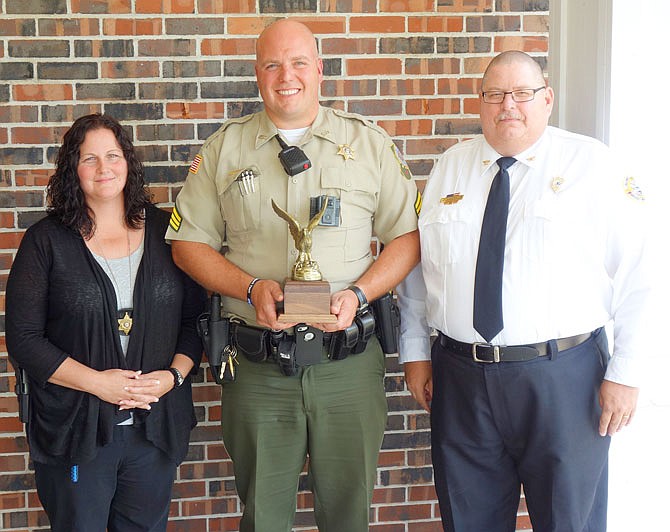 Callaway County Sheriff's Office Sgt. Ryan Lacey (center) was named George W. Law Law Enforcement Officer of the Year on Wednesday by members of the Fulton Rotary Club. The G.W. Law award was presented to him by Charles Anderson, director of the Callaway County Ambulance District. Also nominated was sheriff's Domestic Violence investigator Bettina Korte-Sweede, who received recognition earlier this year at the Callaway County Crime Victims' Right Week Community Ceremony.