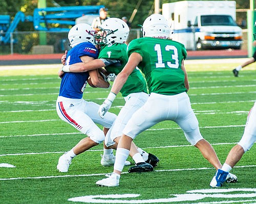 Blair Oaks linebacker Cade Stockman tackles a Moberly ball-carrier as safety Carson Prenger (13) watches during last month's Jamboree at the Falcon Athletic Complex in Wardsville.