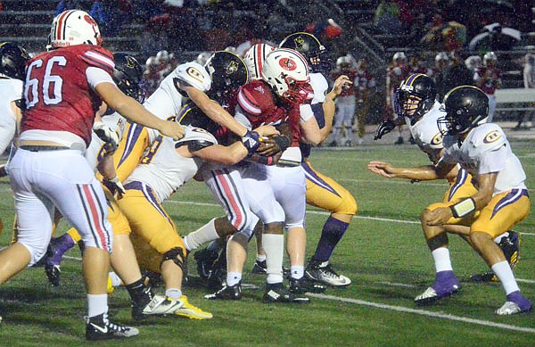 Maleek Jackson of the Jays protects the ball from a slew of Hickman defenders in the rain during last Friday night's game at Adkins Stadium.