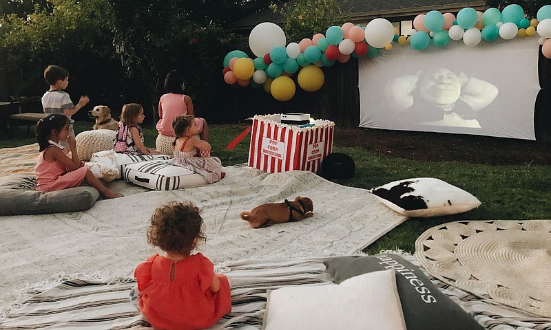 This photo provided by Wittybash.com shows children at a backyard birthday party watching the movie "Shrek" on an outdoor theater setup in Concord, Calif. (Rozalyn Schlumpf/Wittybash.com via AP)