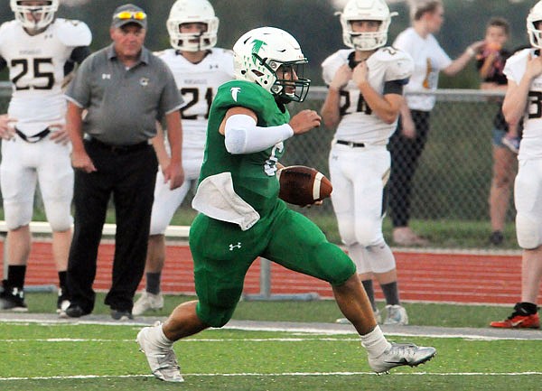 Blair Oaks quarterback Nolan Hair rushes for a gain during Friday's game against Versailles at the Falcon Athletic Complex in Wardsville.