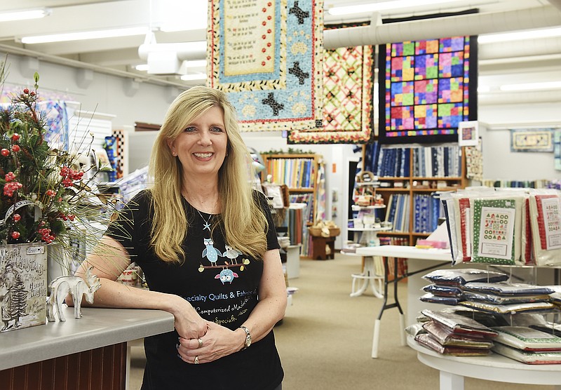 
Linda Foulke, owner of Specialty Quilts, poses near the store's entryway. Foulke recently moved to this location at 2115 Industrial Dr. which gives her more display room and work space to teach quilting, to sell notions and supplies and to have her commercial quilting machines in action. 