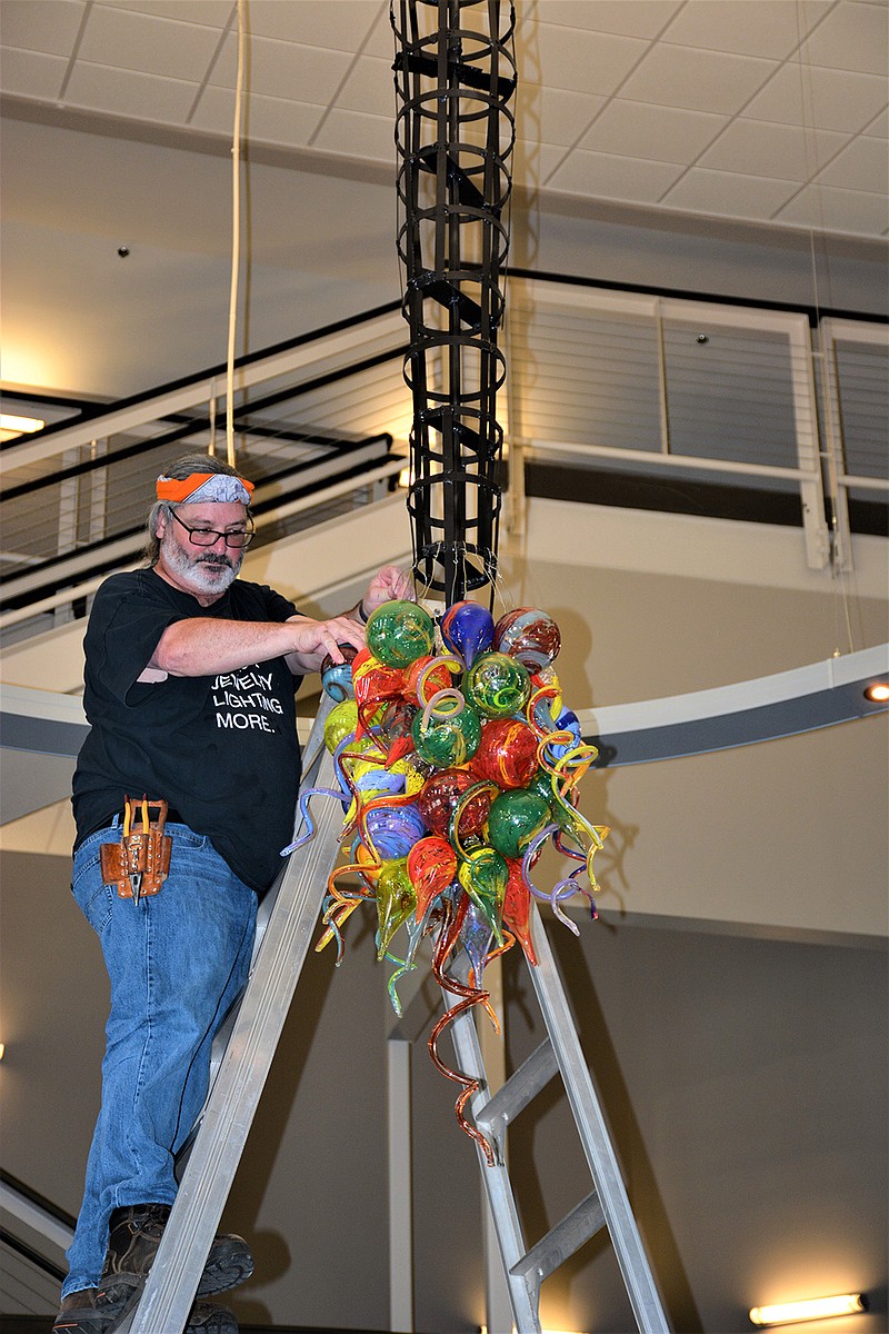 Glass artist James Hayes puts together his "Visions of Harmony, Colors of Hope" chandelier which now hangs in the rotunda of Hempstead Hall on the campus of the University of Arkansas at Hope. A Pine Bluff, Ark., native, Hayes created the 714-piece installation with specific colors to represent Hempstead County and the university. (Submitted photo)