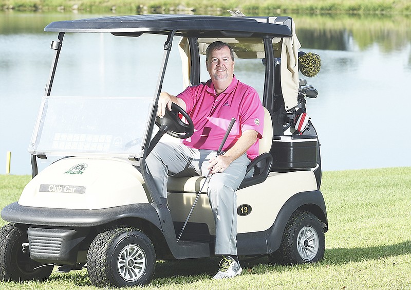 Kevin Dunn, golf pro at Jefferson City Country Club, poses for a photograph near the course pond.