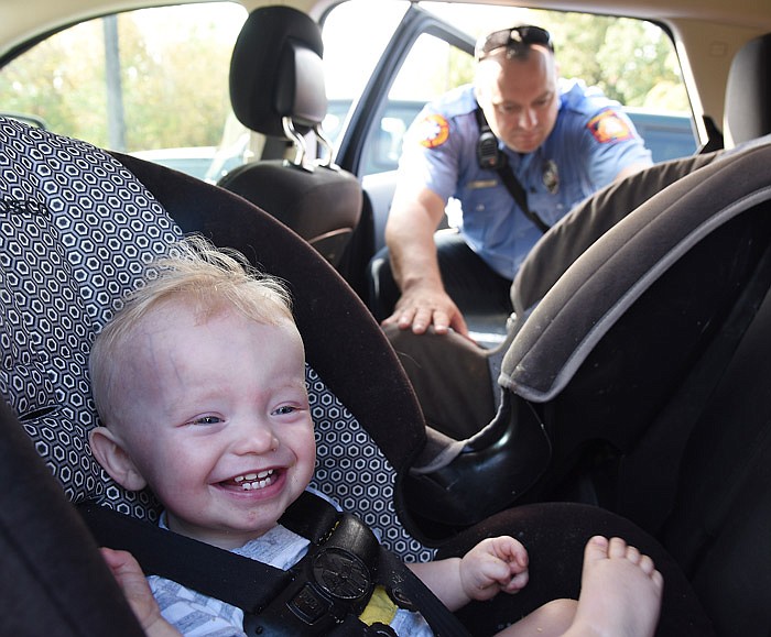 In this Sept. 19, 2017 file photo, one-year-old Chase Czeschin isn't quite sure what to think but seems to be entertained as Jefferson City firefighter Clint Hays inspects the child safety seats in the family's vehicle during a voluntary safety event at the MoDOT Central District office, 1511 Missouri Blvd. 