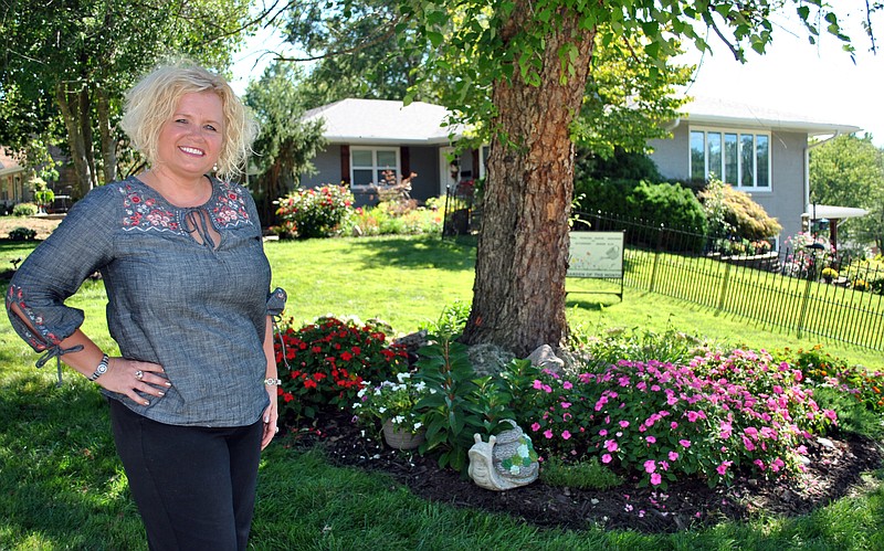 <p>(Photo by Samantha Pogue) Heather Brown stands by one of her favorite and first colorful garden spots in front of her now award-winning home, which earned the September Garden of the Month from the Bittersweet Garden Club.</p>