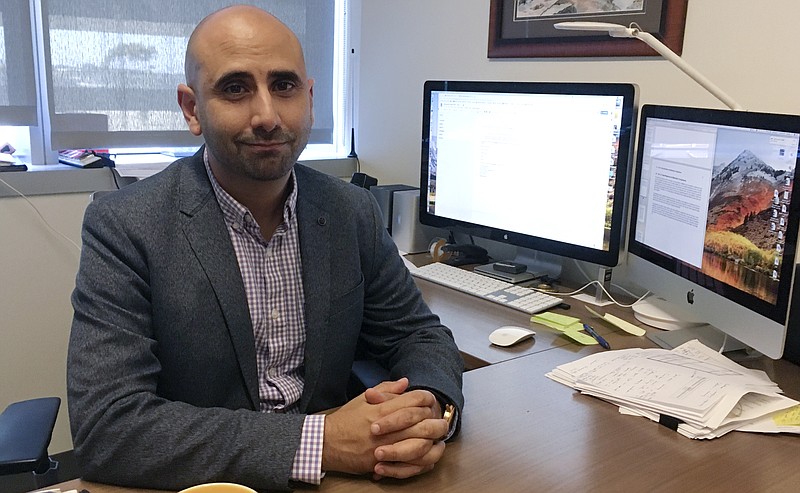 Dr. Fatta Nahab, a neurologist who directs the Functional Imaging of Neurodegenerative Disorders Lab at the University of California San Diego Health's Movement Disorder Center, sits at his desk Monday, Sept 17, 2018, in San Diego. Nahab spent years going through regulatory hoops to get approval to import marijuana from Canada, to study whether cannabis can help treat essential tremor, a shaking condition affecting millions of people. (AP Photo/Julie Watson)