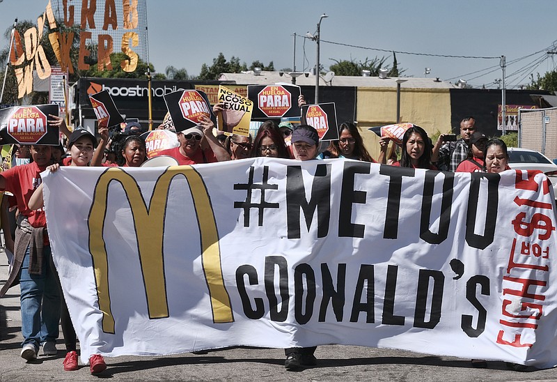 McDonald's workers carry a banner and march towards a McDonald's in south Los Angeles on Tuesday, Sept. 18, 2018. McDonald’s workers staged protests in several cities Tuesday as part of what organizers billed as the first multistate strike seeking to combat sexual harassment in the workplace. (AP Photo/Richard Vogel)