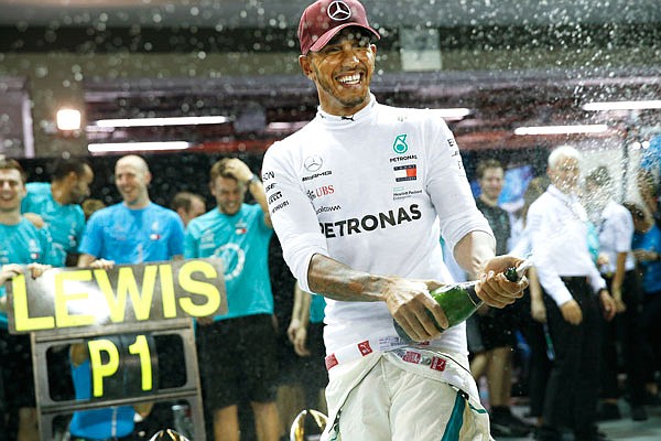 Lewis Hamilton sprays champagne as he celebrates with his team after winning the Singapore Formula One Grand Prix on Sunday at the Marina Bay City Circuit in Singapore.